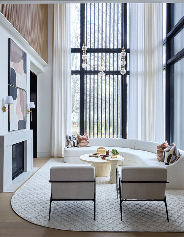 Modern living room with curved sofa and floor-to-ceiling windows dressed in sheer Cortina drapery
