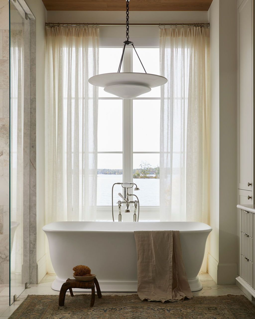 Bathroom with freestanding tub and sheer curtains