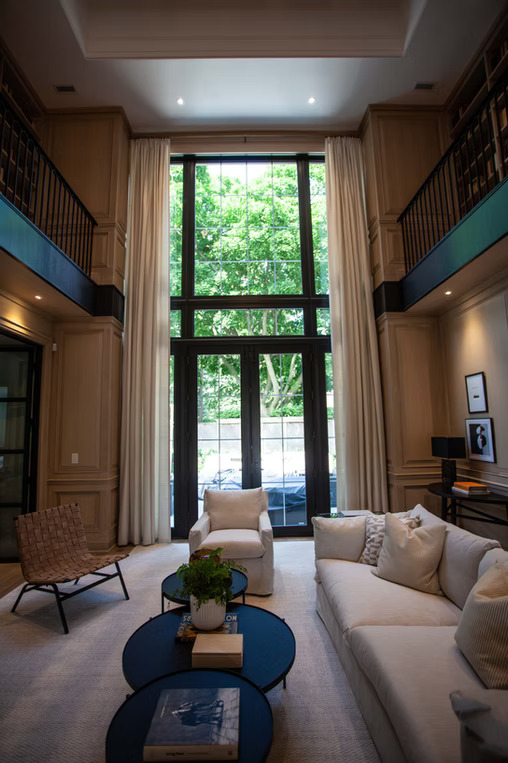 Double-height living room with floor-to-ceiling cream drapery