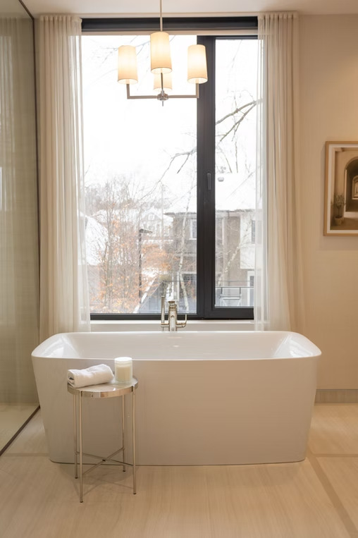 Bathroom with freestanding tub and sheer curtains