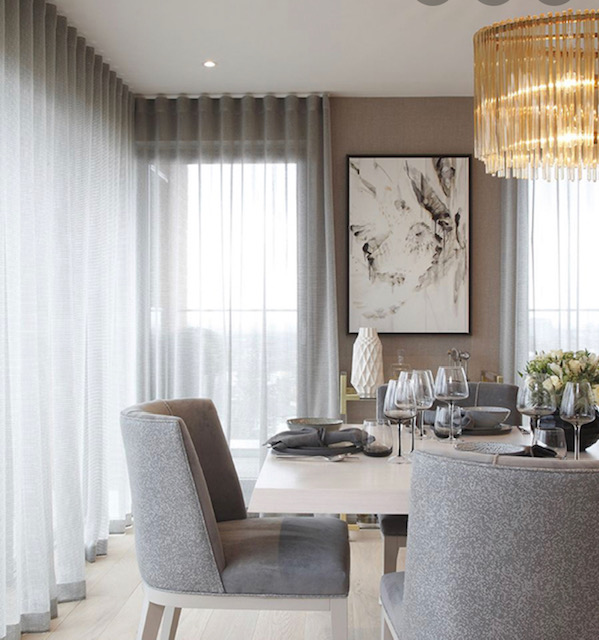 Contemporary dining room with ripplefold sheers and gold chandelier
