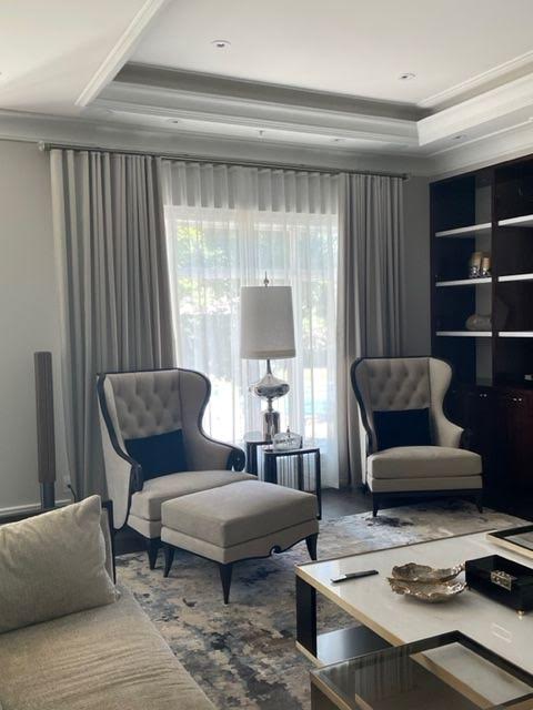 Elegant sitting room with layered sheers and pinch pleat drapery