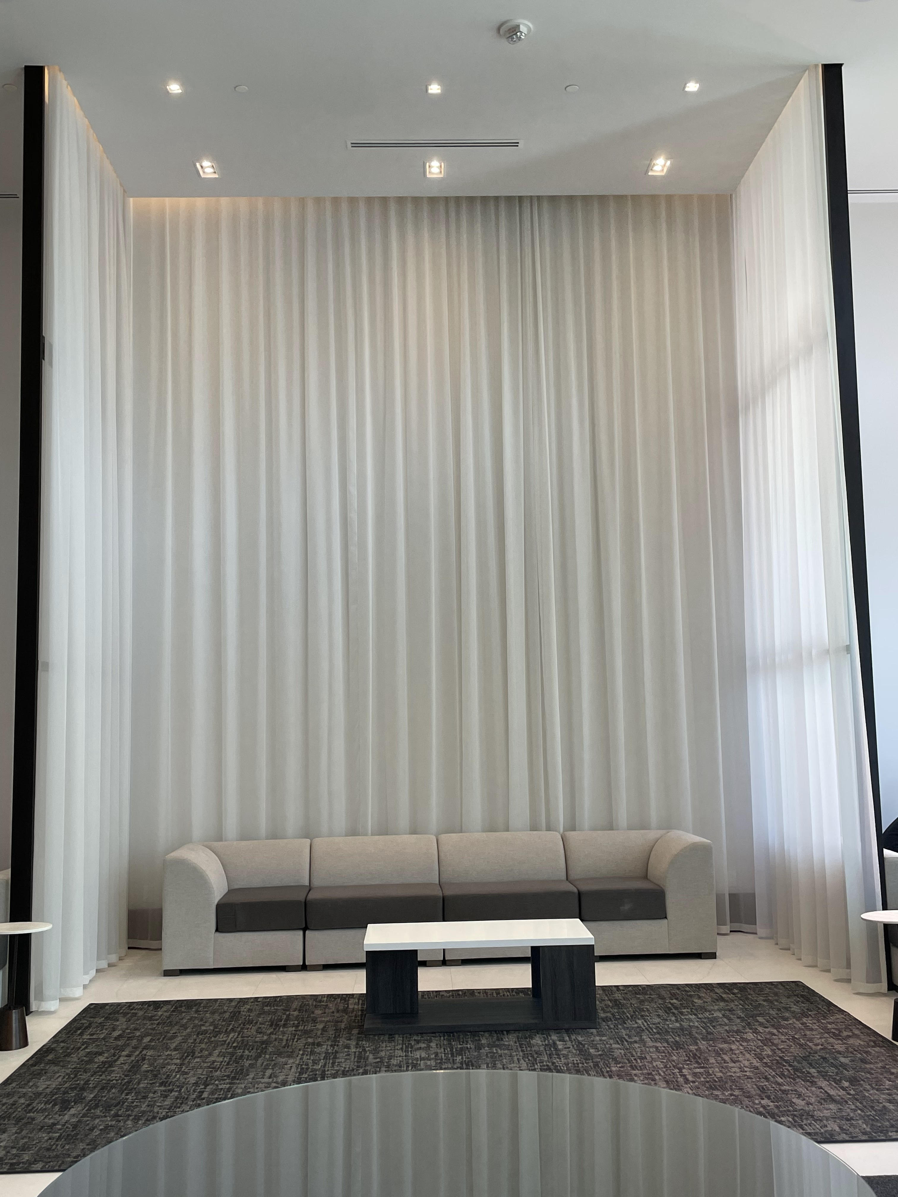 Dramatic lounge with floor-to-ceiling sheer curtain wall